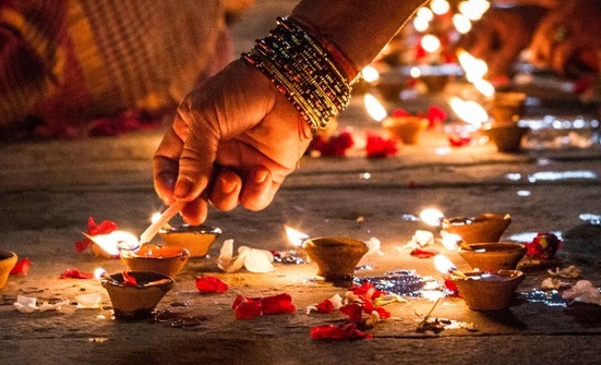 Close-Up Of Hand Holding Illuminated Candles