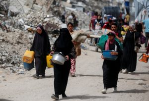 Palestinians make their way with belongings as they flee their homes, in the northern Gaza Strip